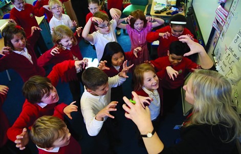 Trainee teacher leading a classroom activity with primary pupils