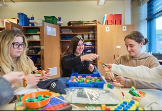 Group of teaching students using maths specialist equipment