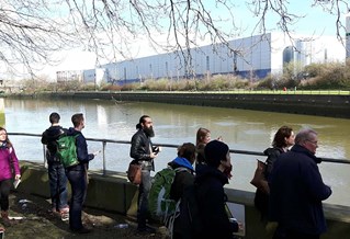 Town planning students on a field trip standing by a wide river