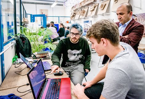 Students around a laptop in an Architectural Technology studio
