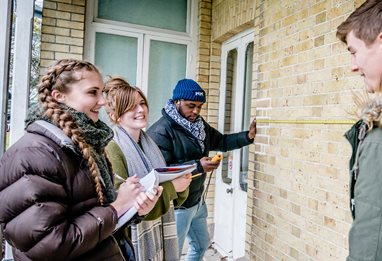 Building surveying students measuring property