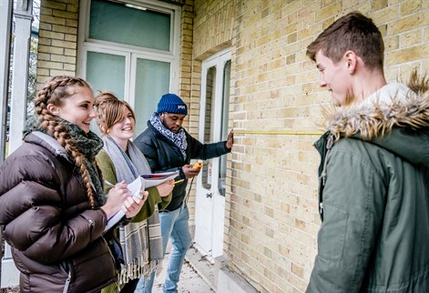 Building Surveying students by a wall