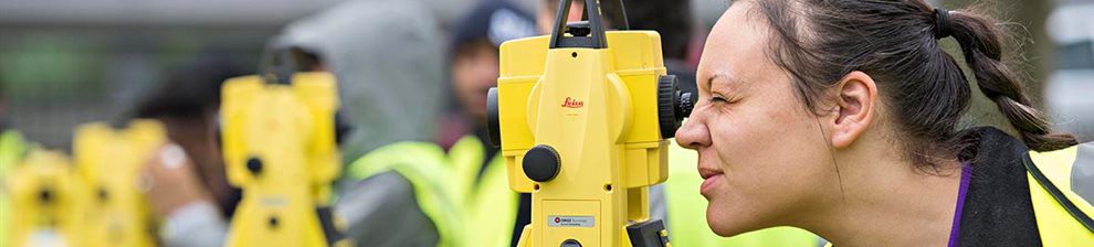 Banner image representing Civil Engineering research, shows researcher looking into landscape levelling equipment