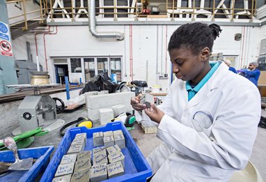 Female student in lab looking at concrete samples