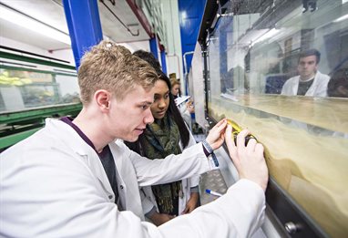 Students measuring sediment in a water flume