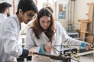 Male and female student using equipment in lab