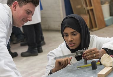 Female student showing measurement to male student in concrete lab