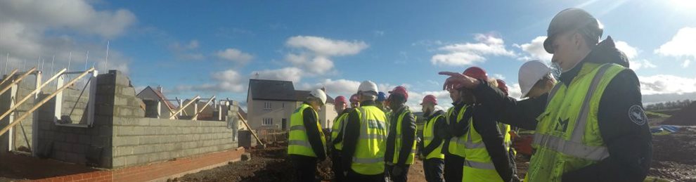 Quantity Surveying Bsc Hons - group of students outside in hi viz discussing a construction site