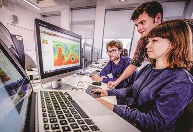 Three students looking at digital maps