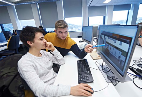 Two students discussing work in the computer lab
