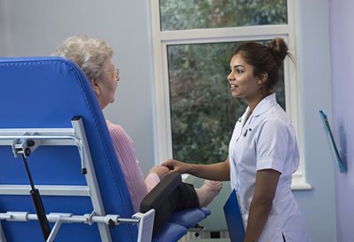 Student holding the hand of a seated patient