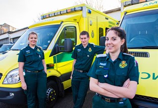 Paramedic practice students in front of ambulances