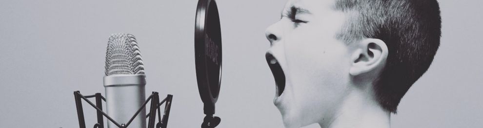 Young boy singing into microphone in black and white