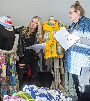 a student and a member of staff look through the dress history collection