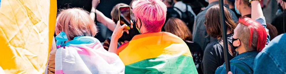 people at a parade wearing rainbow flags