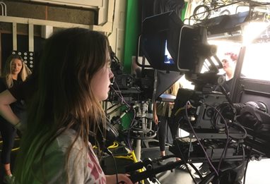 Student operating a camera in a studio