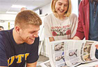 Two students looking through newspapers