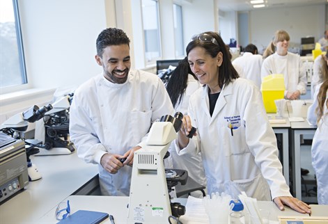 Student and staff in white coats looking wearing white coats