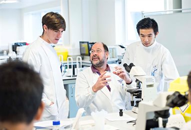 Lecturer explaining things to two students in the lab