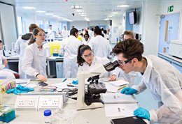 Students in white coats in a lab
