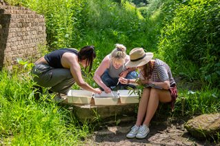 Three students doing a water experiment in the field