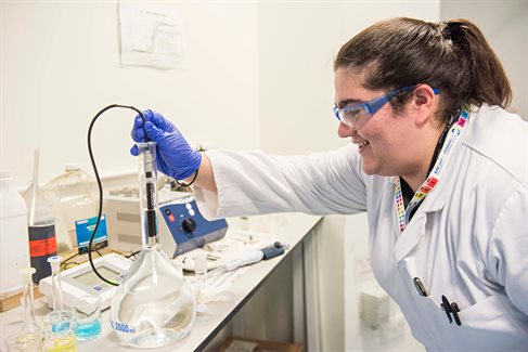 Student testing liquid in glass beaker