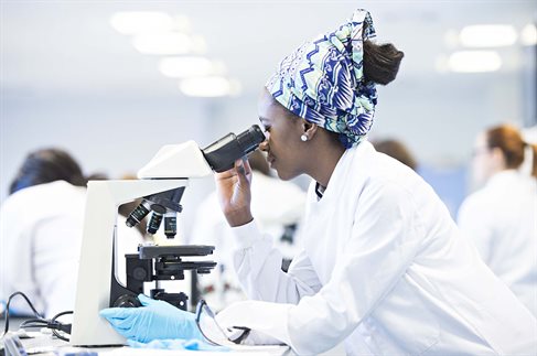 female student using microscope