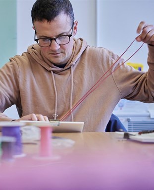 male student sewing