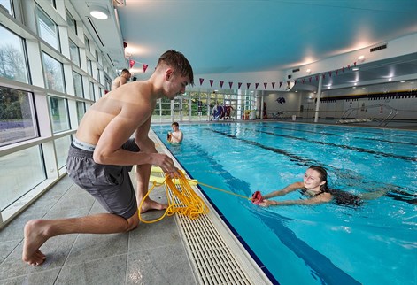 two students practising life saving in the pool