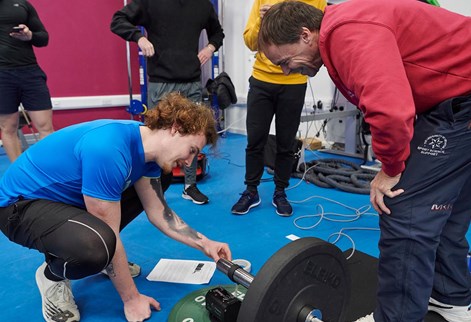 students adjusting weights in the gym