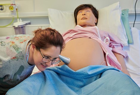 student listening to the mannequins baby's heartbeat