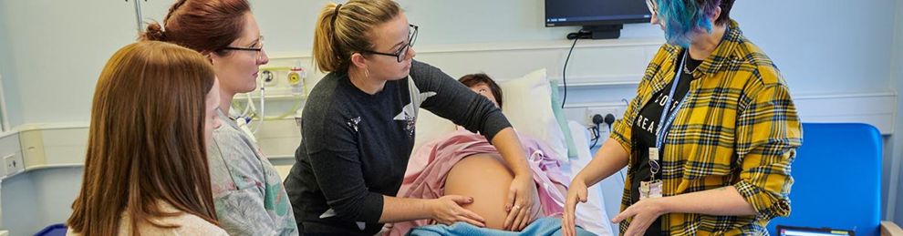 students with the birthing mannequin