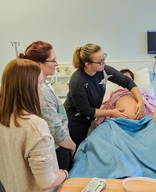 students with the birthing mannequin