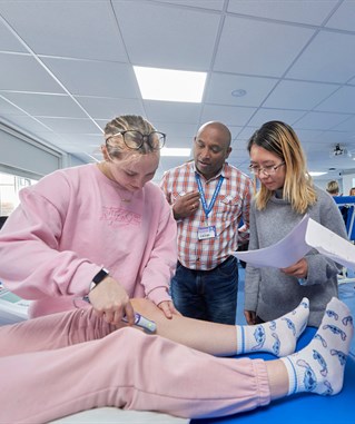 Group of students with lecturer in physio suite