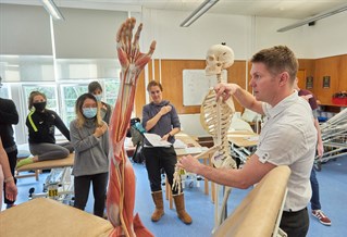 Lecturer using a skeleton to explain movement