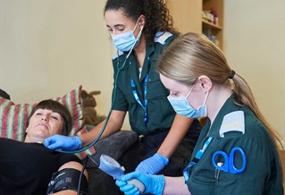 Paramedic students with a patient in our community flat