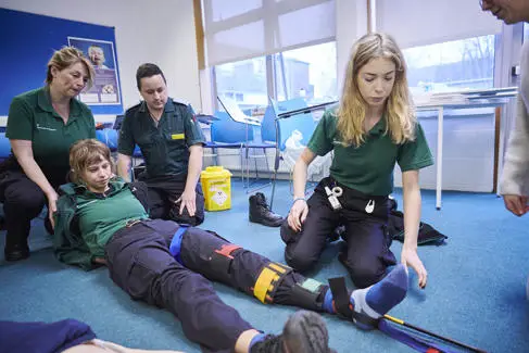 student paramedics putting a splint on a fellow student