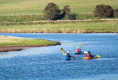 Three people in canoes on a river