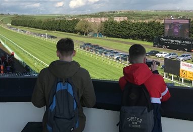 Two students looing over a horse racing course