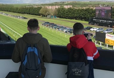 People watching horseracing with binoculars