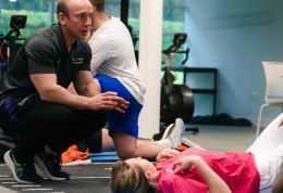 Course leader giving feedback to person on floor