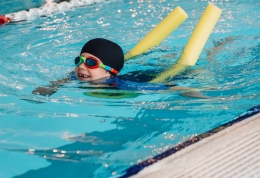 Happy child swimming with float