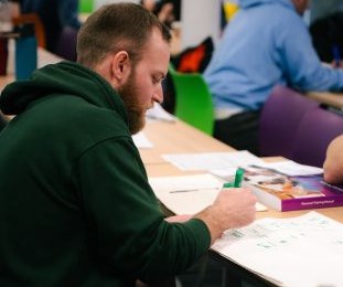 person writing in classroom setting