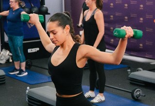 Student in exercise class with weights