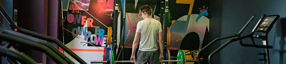 Student holding weights in exercise gym