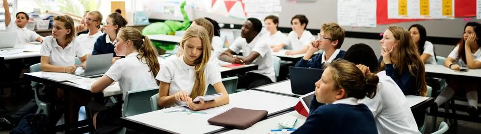 Secondary students taking part in a classroom discussion during a teacher-led lesson.