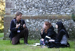 Staff member talking to two students in a garden