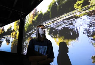 Student in front of a projection of a lake