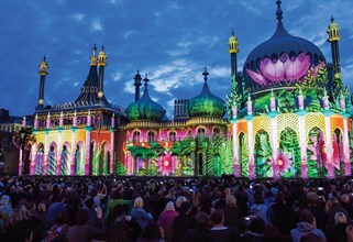 Brighton Pavilion illuminated at night in a light display of multicoloured leaves and flowers