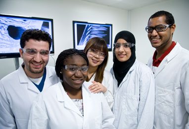 Five students in white lab coats